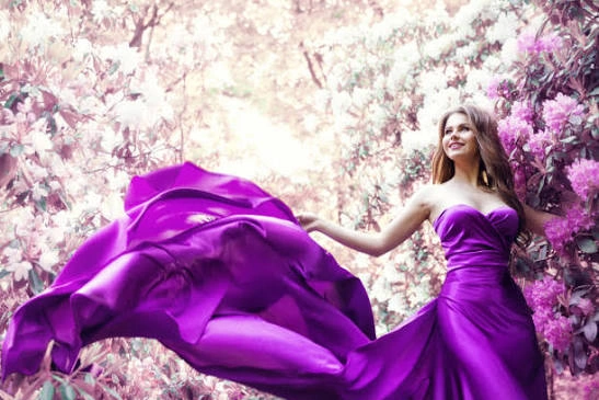 Confident woman in a purple dress posing for Instagram